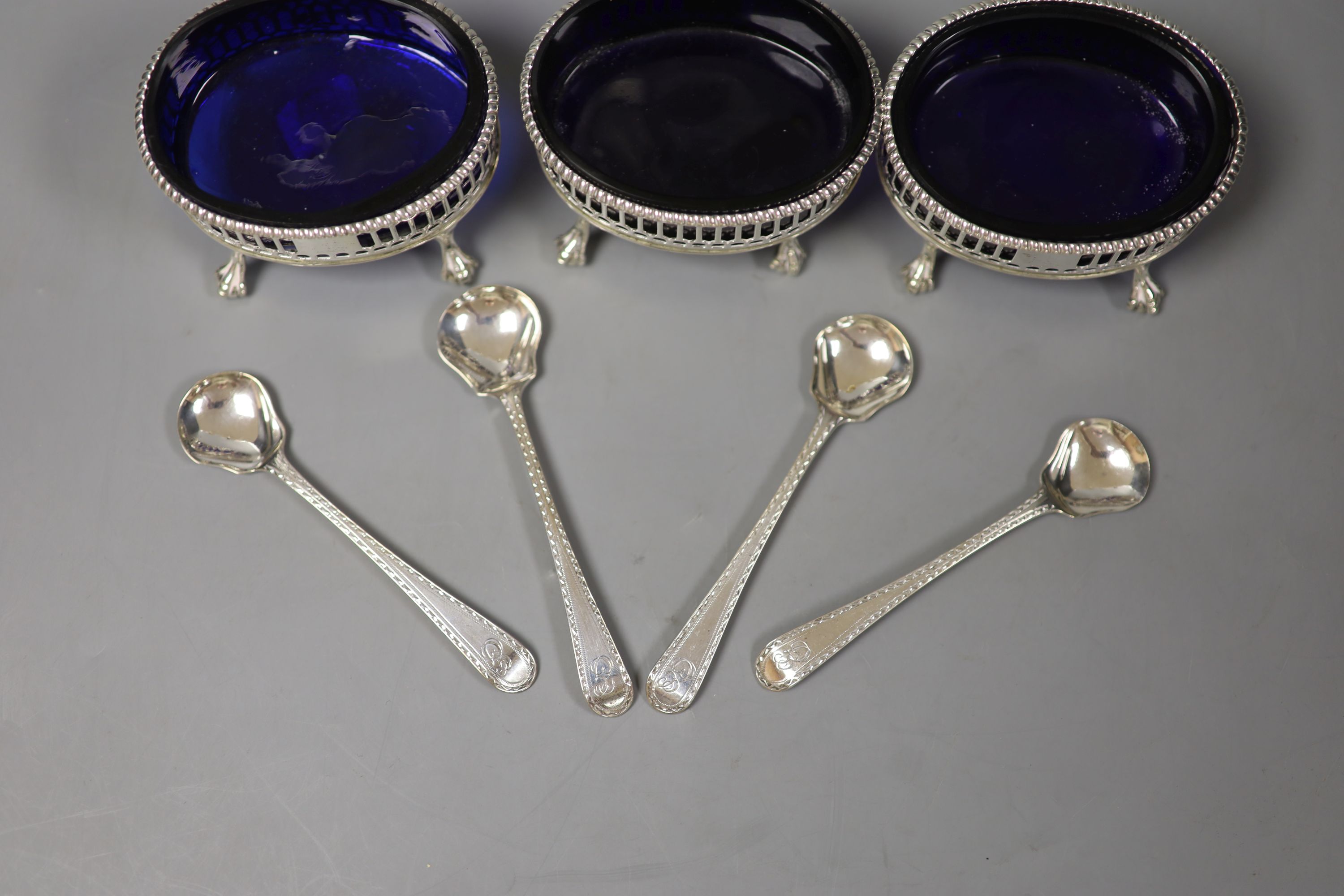 A set of three George III oval pierced silver salts, D & R Hennell, London 1771, 81mm and four bright cut spoons.